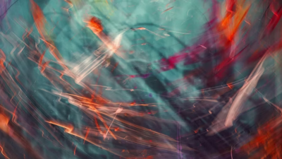 An abstract image featuring energetic, swirling light trails in vibrant shades of neon orange, deep red, and bright white, set against a mottled, dark teal and cyan background. The blurred, sweeping lines create a dynamic sense of fluid motion, resembling long-exposure photography or energetic, glowing brushstrokes.